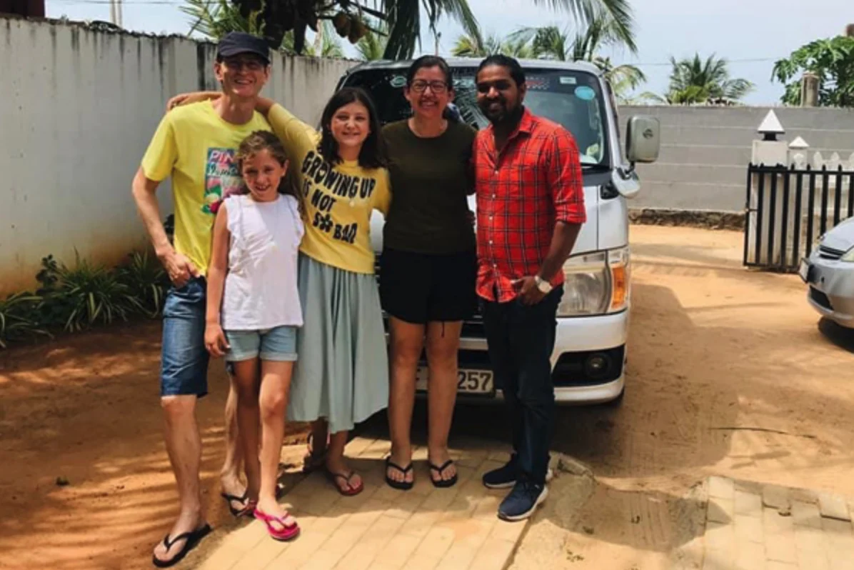 Family and private driver beside a passenger van in Sri Lanka