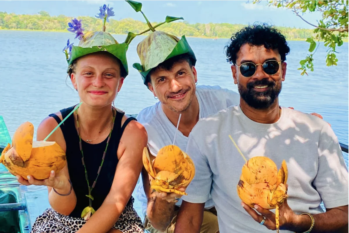 Traveling couple sharing a local coconut experience with their Sri Lankan guide-driver