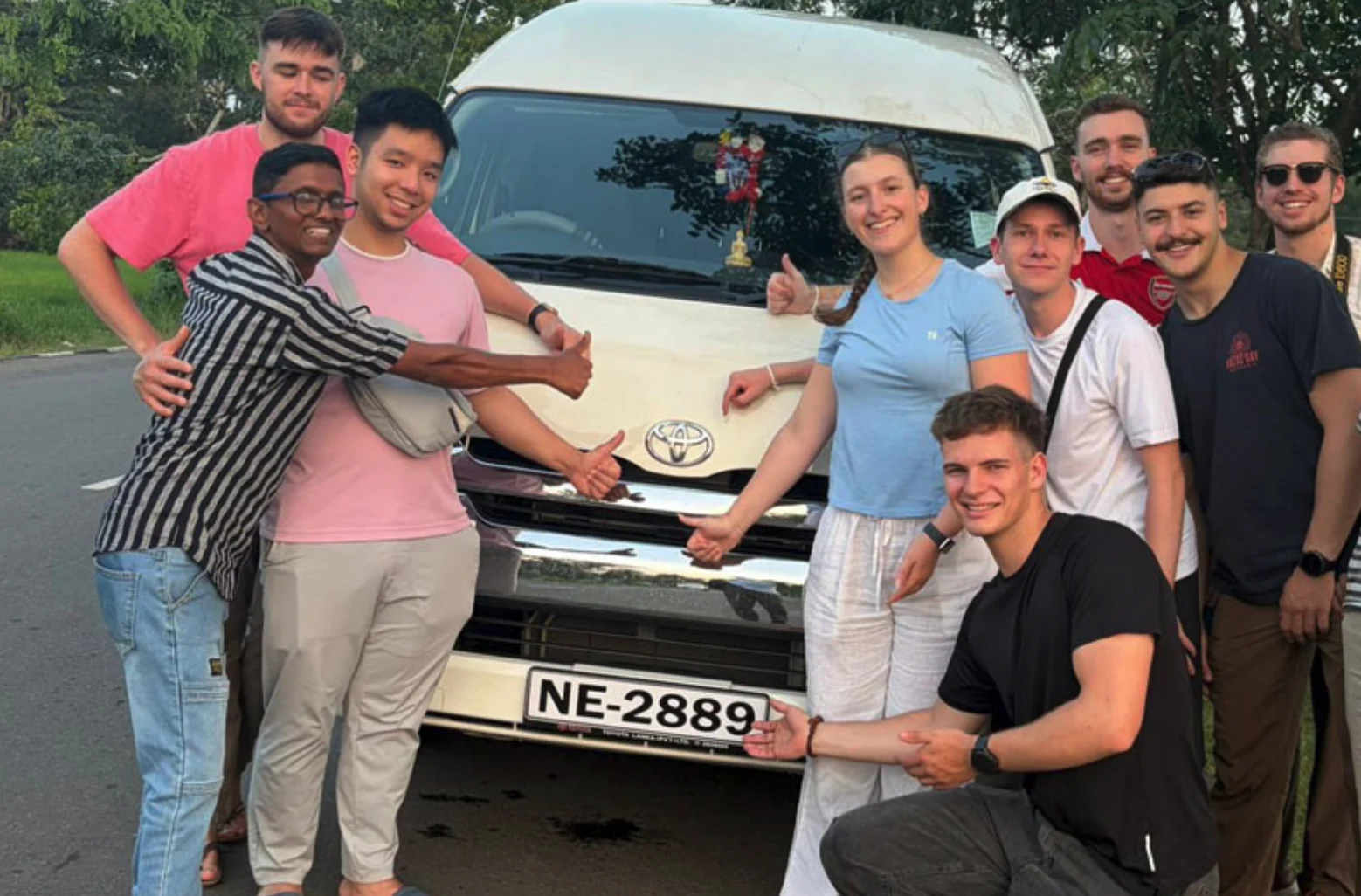 Group of travellers beside a passenger van used for a Sri Lanka tour