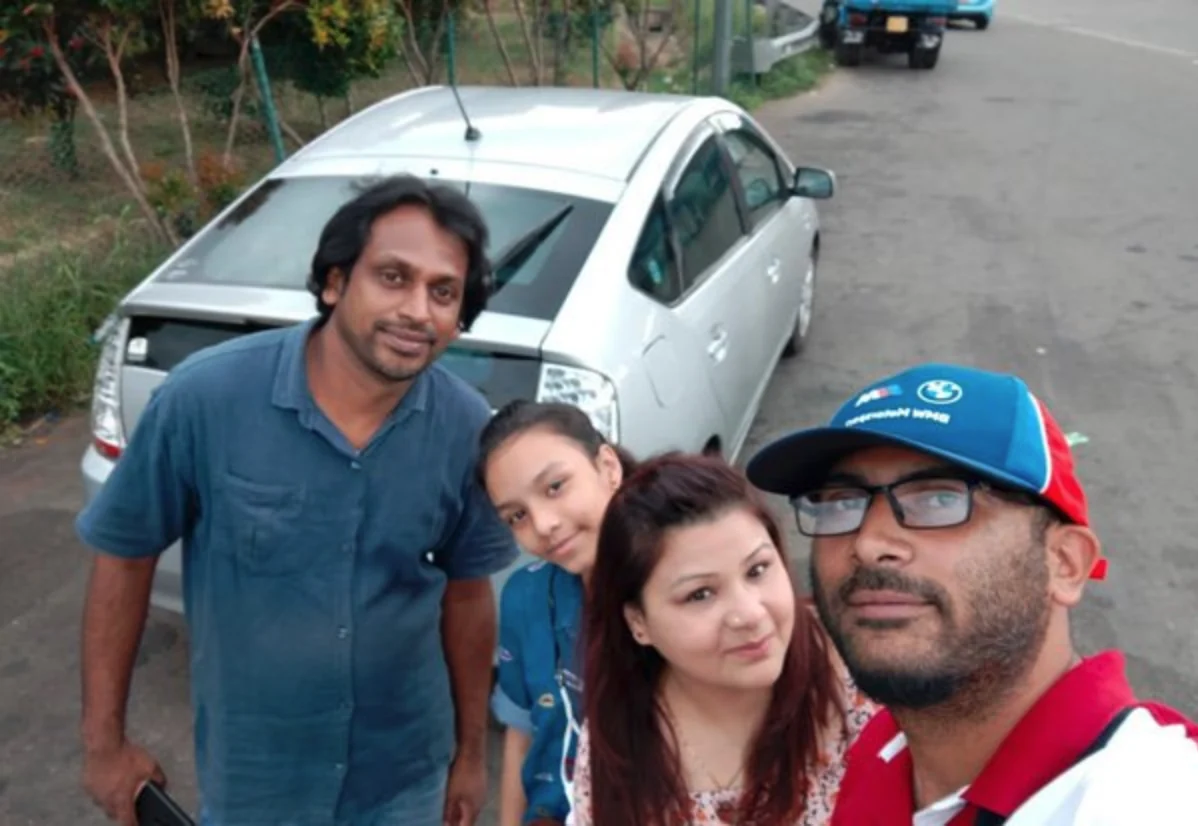 Family and Sri Lankan driver taking a trip photo beside their private car